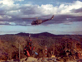 Huey chopper flying over a Christmas tree